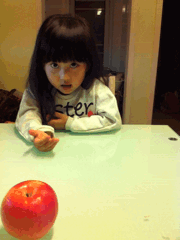 小女孩玩魔术拿苹果